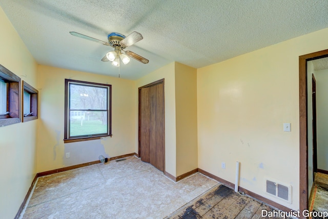 unfurnished bedroom featuring a textured ceiling, a closet, ceiling fan, and baseboards