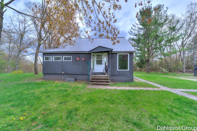 view of front of property featuring a front lawn and metal roof
