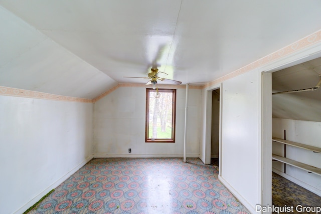 additional living space with vaulted ceiling, a ceiling fan, and baseboards