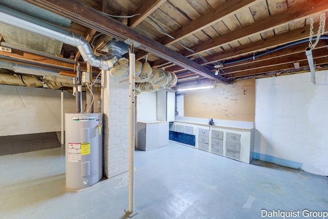 unfinished basement featuring electric water heater and concrete block wall