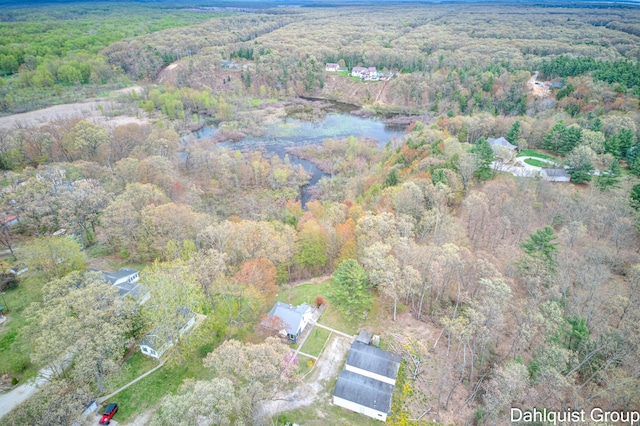 aerial view of property and surrounding area with a forest and a large body of water