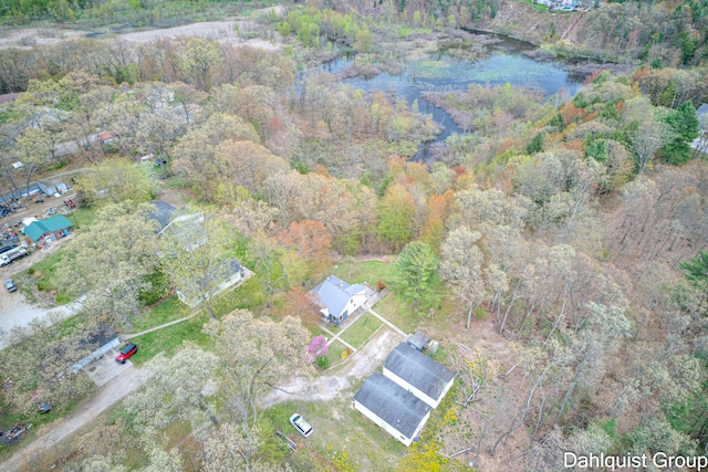 view of property location with a heavily wooded area and a nearby body of water