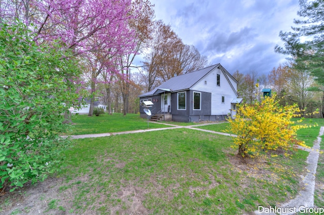 view of front of property with metal roof and a front lawn