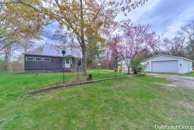 view of green lawn featuring a detached garage and an outdoor structure
