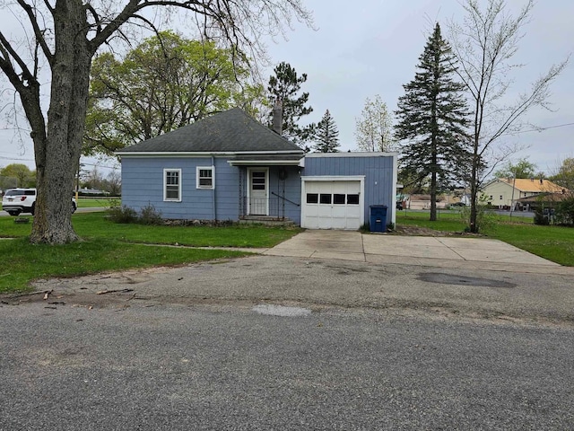 335 Emory St, Howard City, MI 49329 - view of front of home with a front yard, an attached garage, and driveway