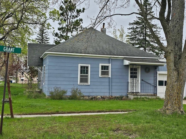 335 Emory St, Howard City, MI 49329 - rear view of property with a shingled roof, a chimney, and a yard