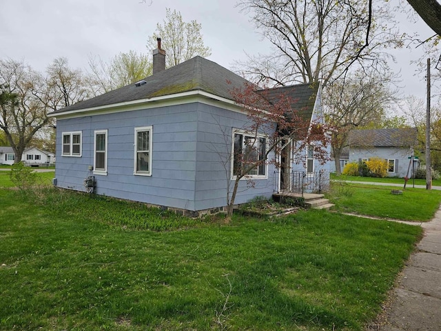 335 Emory St, Howard City, MI 49329 - view of home's exterior featuring a chimney, a yard, and roof with shingles