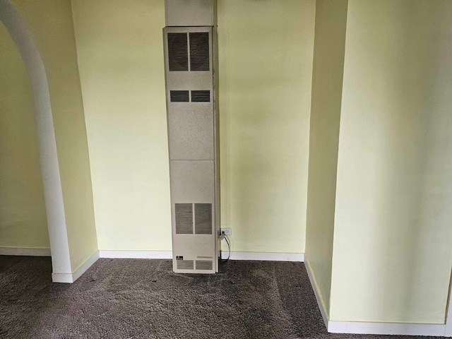 335 Emory St, Howard City, MI 49329 - interior space featuring a heating unit, arched walkways, carpet flooring, and baseboards