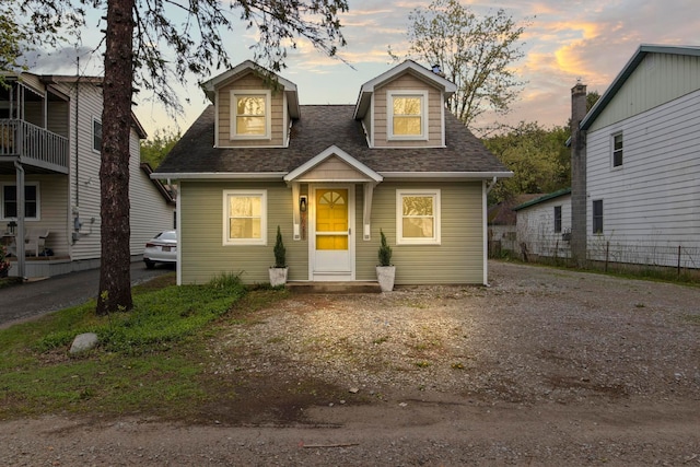 new england style home featuring roof with shingles