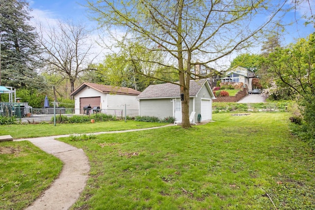 view of yard featuring a detached garage and an outbuilding