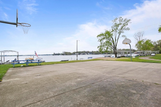 view of sport court with community basketball court and a water view
