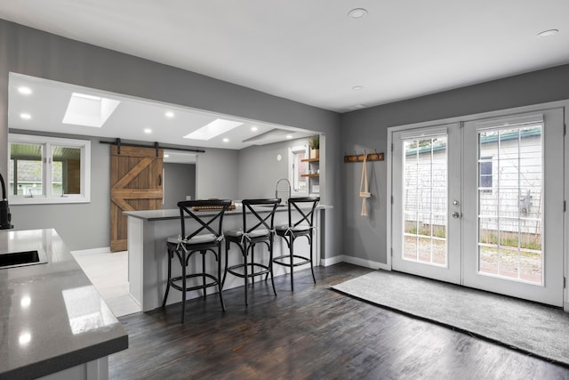 dining area with a barn door, french doors, wood finished floors, recessed lighting, and healthy amount of natural light