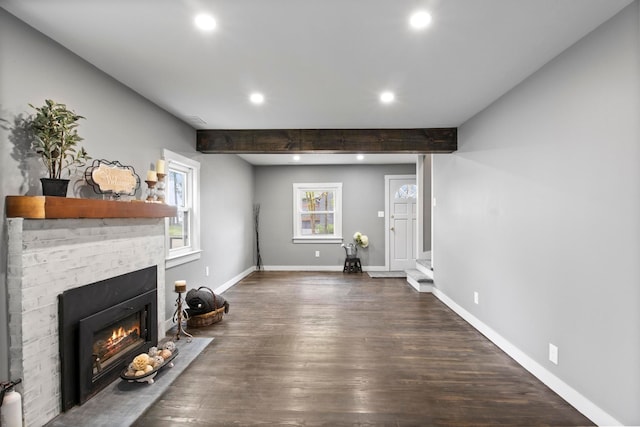 living room with recessed lighting, a fireplace with flush hearth, dark wood-type flooring, baseboards, and beam ceiling