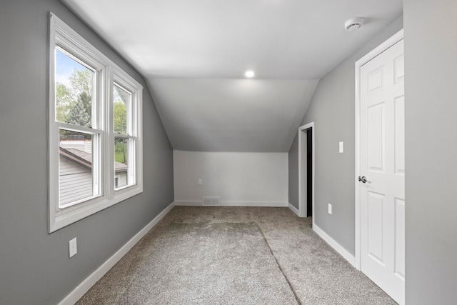 bonus room featuring lofted ceiling, carpet floors, and baseboards