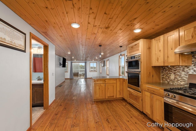kitchen featuring stainless steel appliances, a peninsula, light brown cabinetry, range hood, and open floor plan