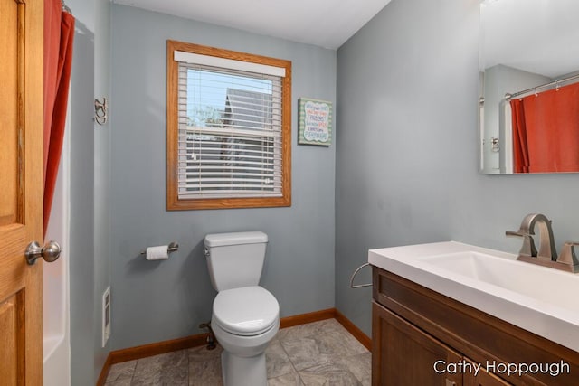 bathroom with toilet, baseboards, and vanity