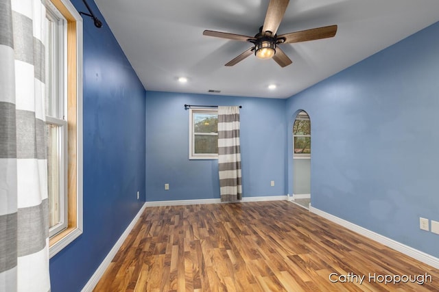 unfurnished room with wood finished floors, ceiling fan, and baseboards