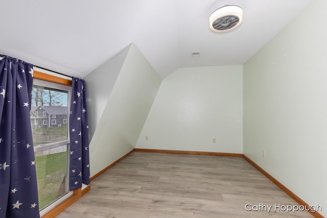 bonus room featuring vaulted ceiling, wood finished floors, and baseboards