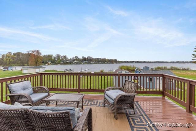wooden terrace featuring a water view and a lawn