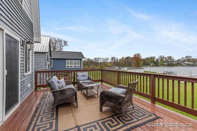 wooden terrace with a water view, an outdoor living space, and a lawn