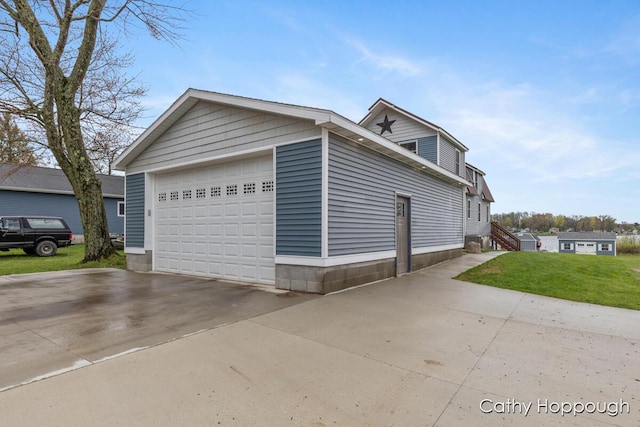 view of property exterior featuring a lawn and a detached garage