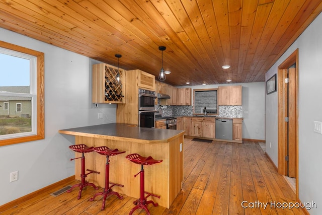 kitchen featuring stainless steel appliances, light wood-style flooring, wood ceiling, a peninsula, and a sink