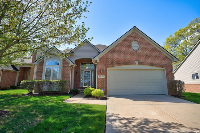 traditional home featuring a front lawn, driveway, an attached garage, and brick siding