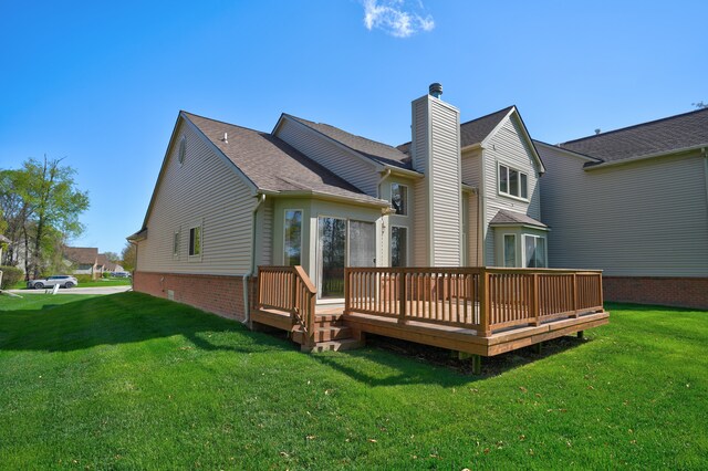 rear view of property with a yard, a deck, a chimney, and a shingled roof