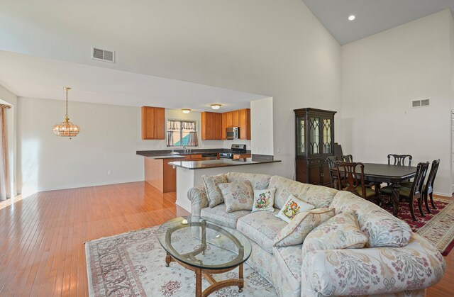 living area with a towering ceiling, hardwood / wood-style flooring, and baseboards