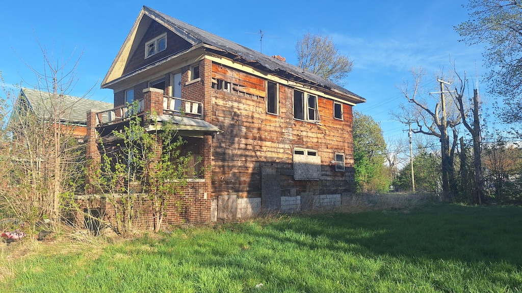 view of property exterior featuring a balcony and a yard