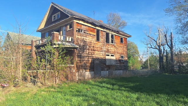 view of property exterior featuring a balcony and a yard