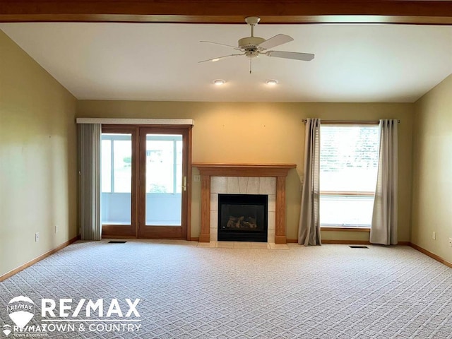 unfurnished living room with carpet flooring, baseboards, ceiling fan, and a fireplace