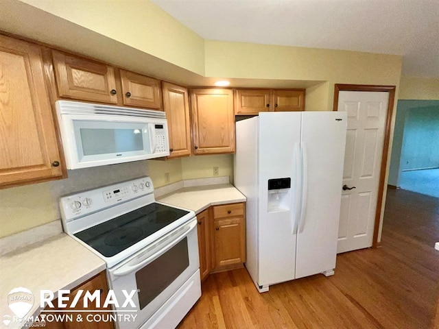 kitchen featuring white appliances, light wood-style flooring, and light countertops
