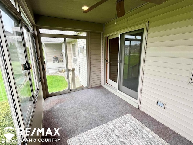 unfurnished sunroom featuring ceiling fan
