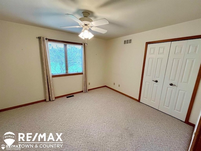 unfurnished bedroom with light colored carpet, a closet, baseboards, and ceiling fan