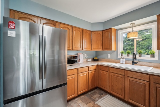 4630 Pasture Ln, White Lake, MI 48383 - kitchen with freestanding refrigerator, a sink, light countertops, pendant lighting, and brown cabinets