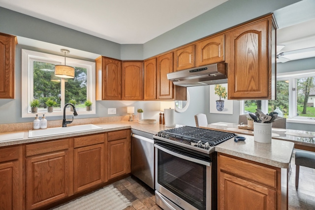 4630 Pasture Ln, White Lake, MI 48383 - kitchen featuring stainless steel appliances, under cabinet range hood, a sink, brown cabinets, and light countertops