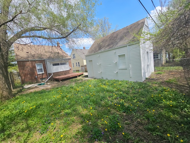 rear view of property with a wooden deck and a shingled roof
