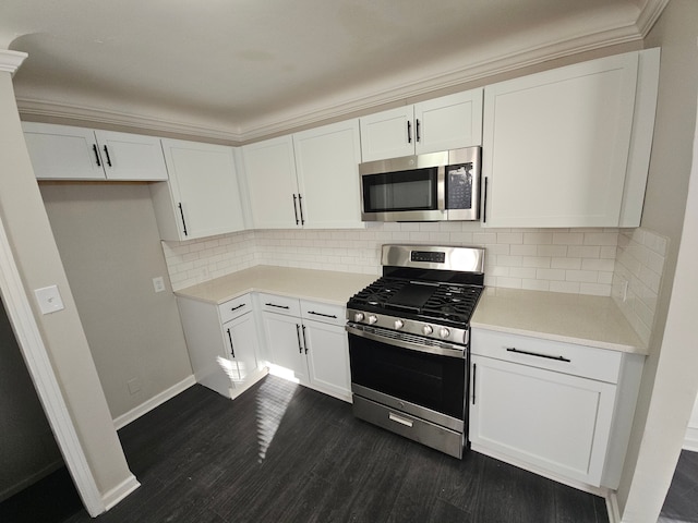 kitchen featuring stainless steel appliances, white cabinets, dark wood finished floors, and light countertops