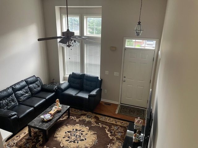living room featuring a ceiling fan, wood finished floors, and baseboards