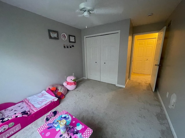 unfurnished bedroom with carpet flooring, baseboards, a closet, and ceiling fan