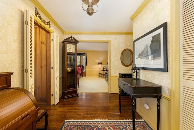 hall with wallpapered walls, hardwood / wood-style flooring, and crown molding