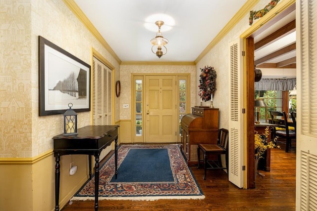 entrance foyer featuring wallpapered walls, wood finished floors, crown molding, baseboards, and beamed ceiling