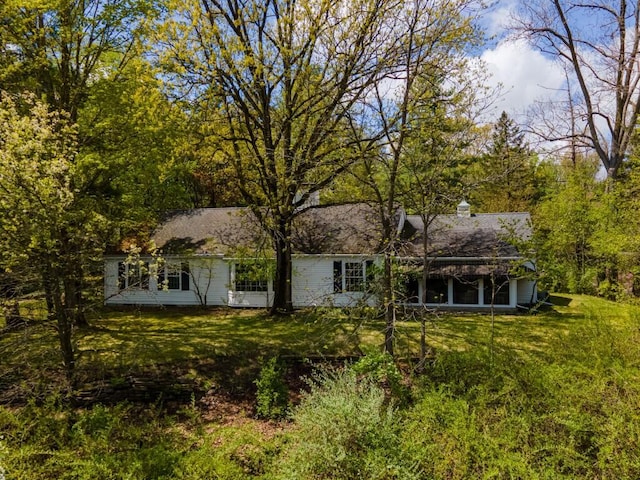 back of house with a yard and a chimney