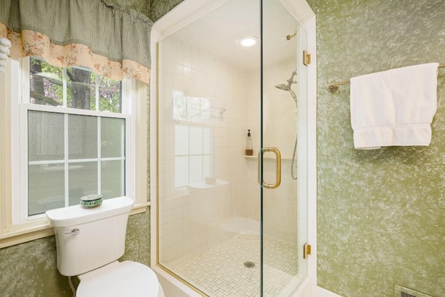full bath featuring toilet and a stall shower