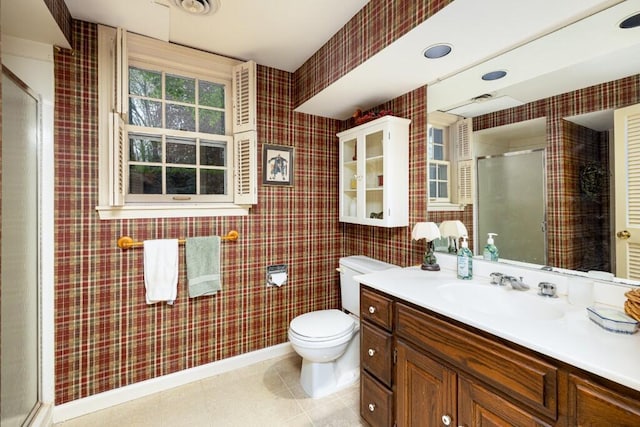 full bathroom featuring a stall shower, toilet, vanity, baseboards, and wallpapered walls