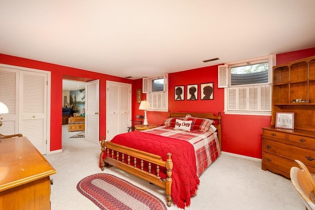 bedroom featuring multiple closets, carpet, and baseboards