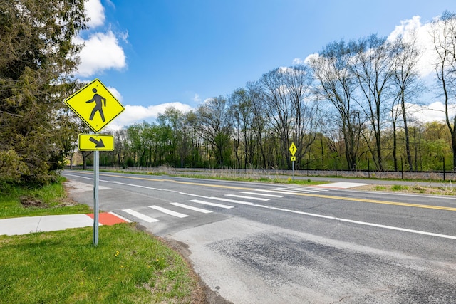 view of asphalt street with traffic signs
