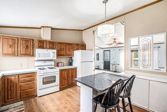 347 Lou Alice Dr, Columbiaville, MI 48421 - kitchen with white appliances, brown cabinetry, ornamental molding, light wood finished floors, and a breakfast bar area