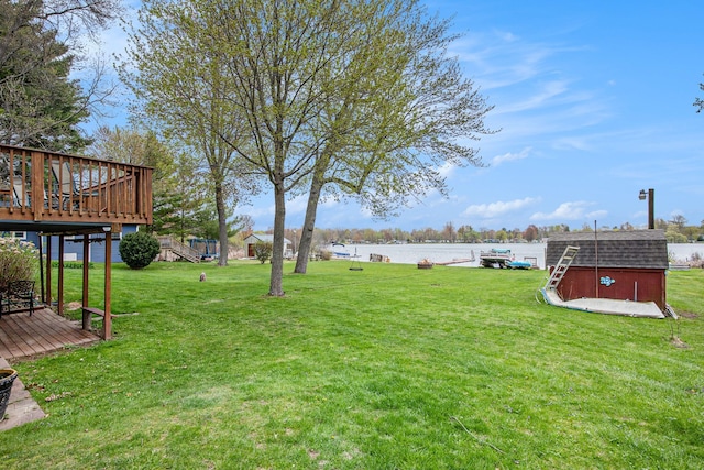 347 Lou Alice Dr, Columbiaville, MI 48421 - view of green lawn featuring a deck with water view, a storage shed, and an outdoor structure